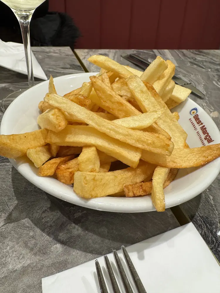 Bowl of thick hand-cut chips on a Best Mangal plate